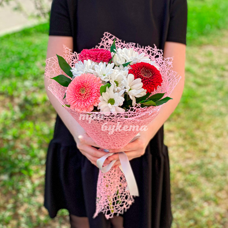 Герберы и хризантемы в розовом сизале (в руках флориста)